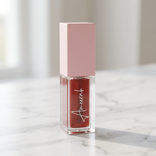 Ameerah The Royal Range Rosewood lip oil bottle with pale pink cap standing on white marble